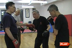 William Chen demonstrates uppercut to Steven A. and Kan K.